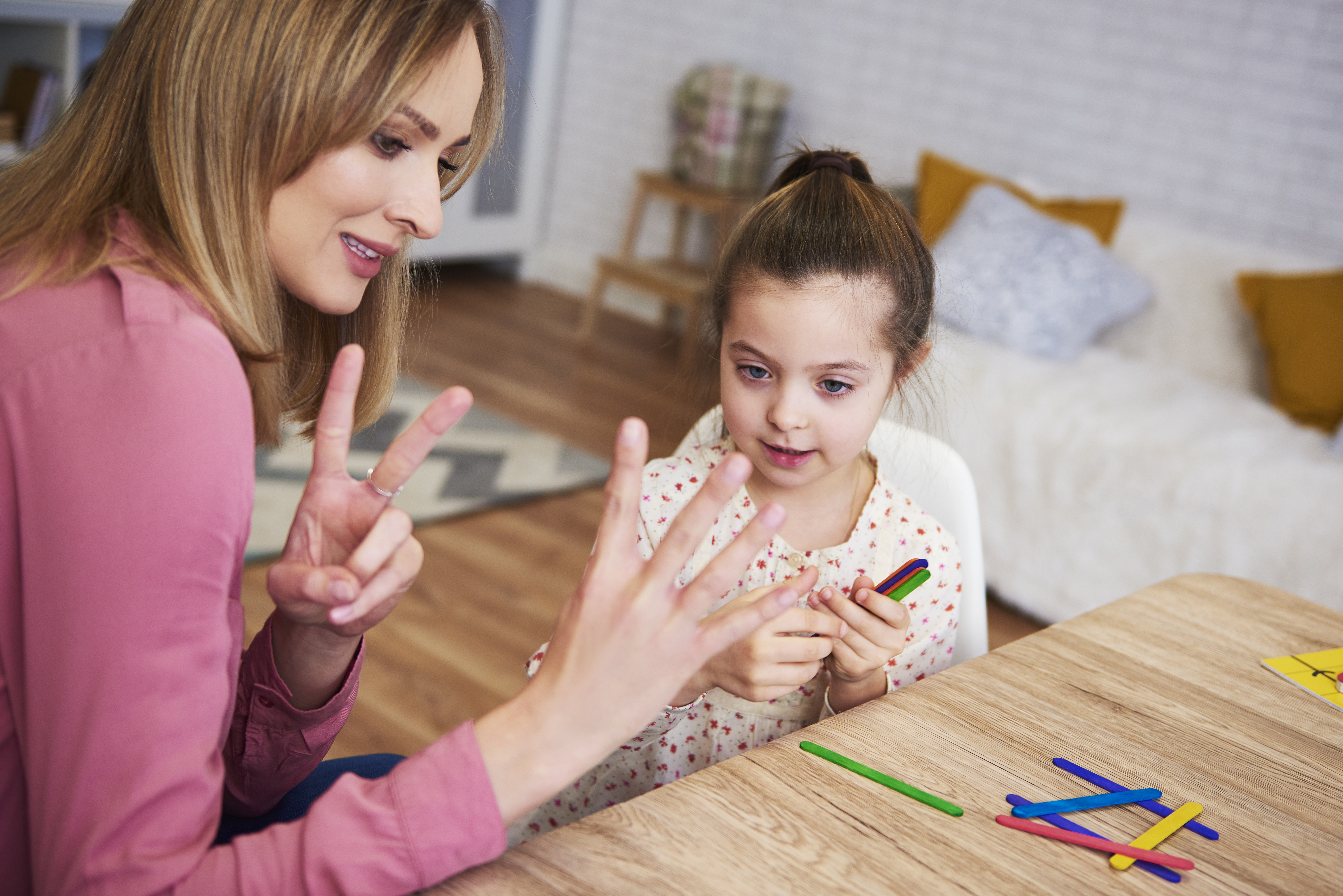 a teacher is teaching a child speech therapy 